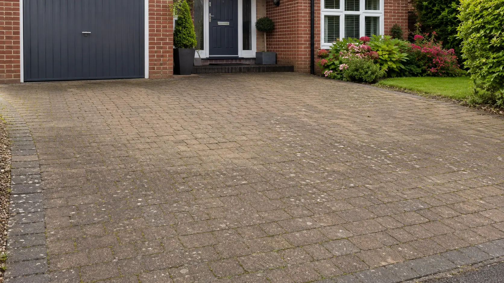 Before and after of a driveway being cleaned.